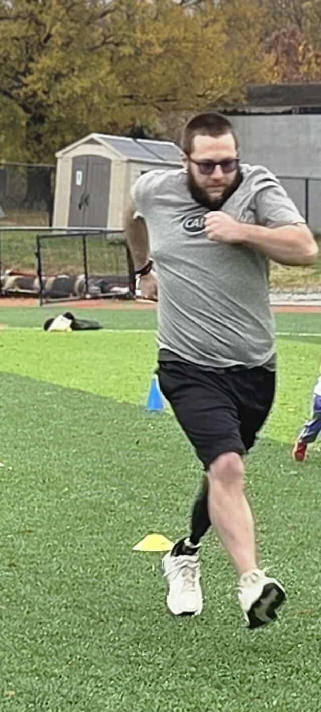 Michael running on turf with his prosthetic leg at the CAF clinic