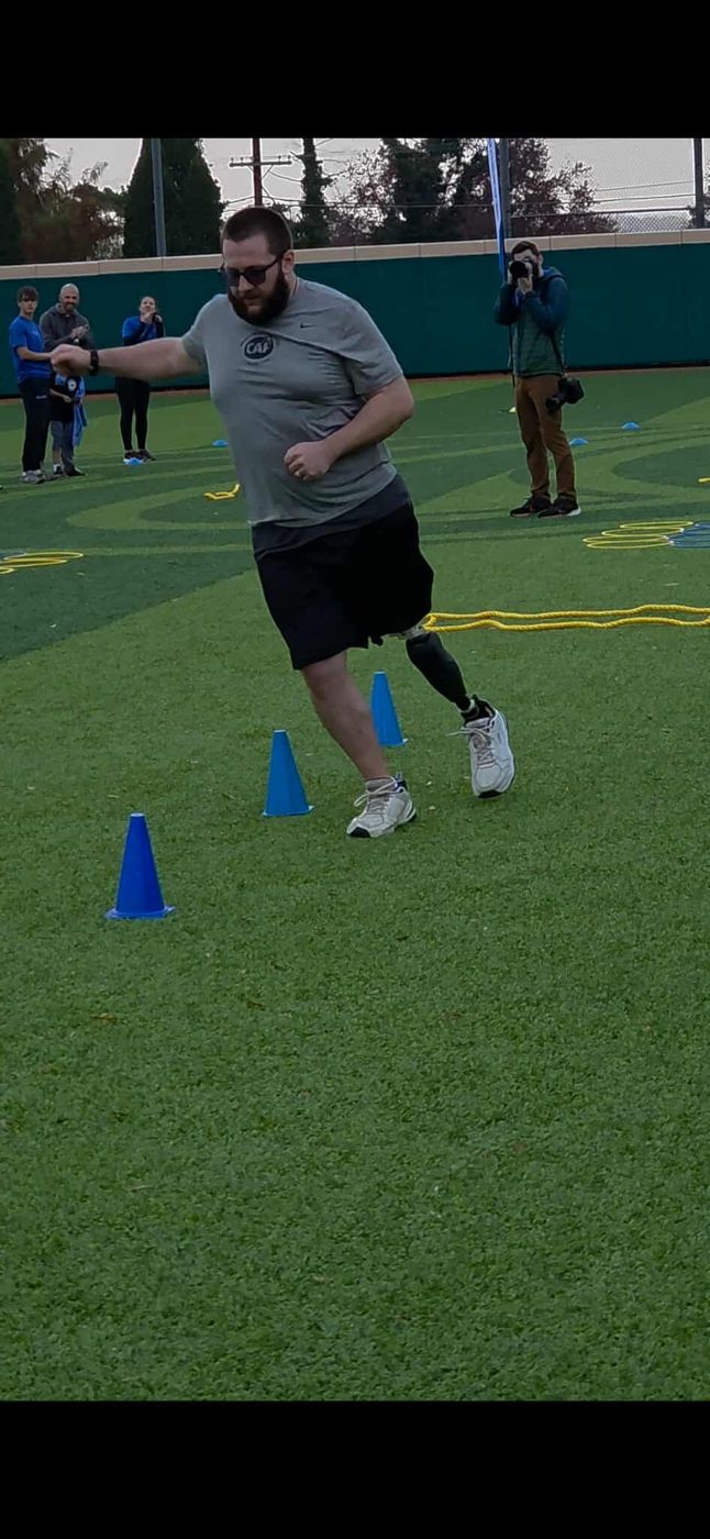 Michael running through cones at the CAF clinic as a photographer watches